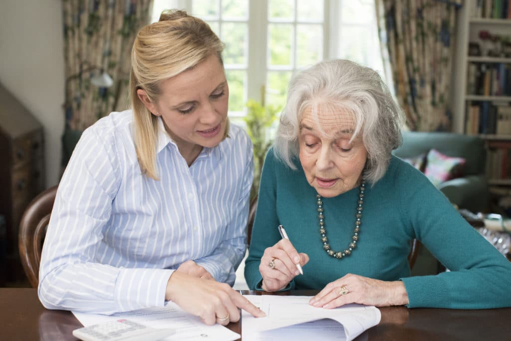 Caregiver Helping Parent With Power of Attorney Paperwork | Medicare Plan Finder