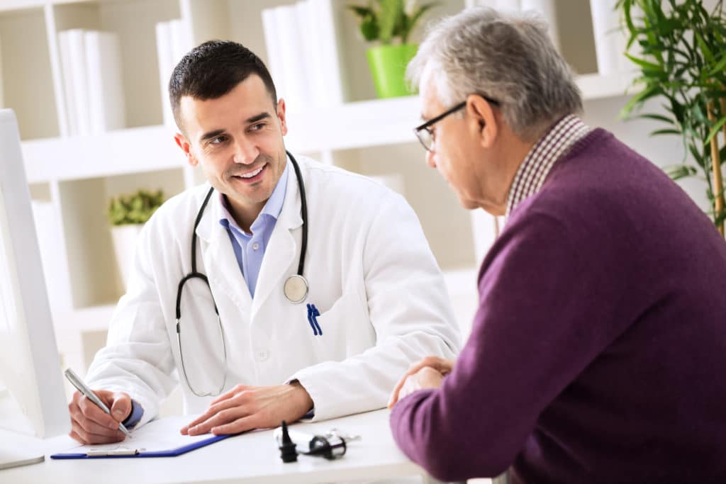 Rheumatologist talking to patient about rheumatoid arthritis treatment | Medicare Plan Finder